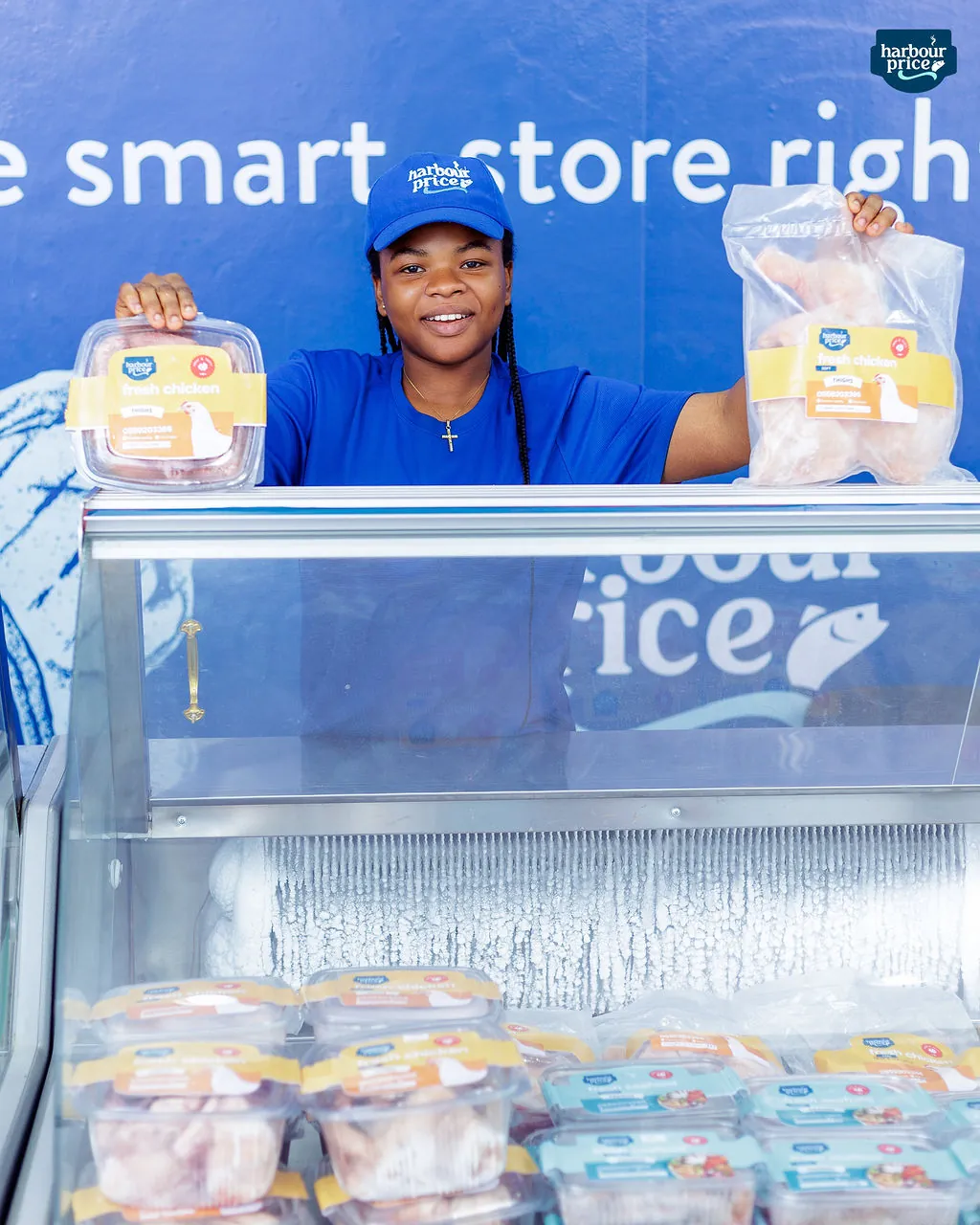 A Harbour Price staffer holds up labelled packs of fresh chicken above the chilled counter