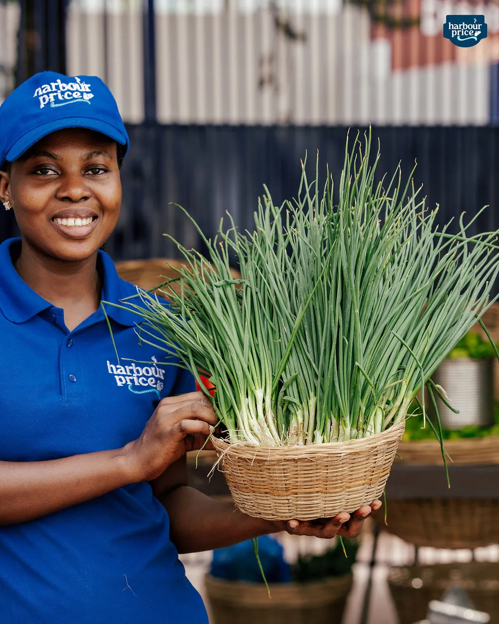A Harbour Price staffer holds a basket of fresh spring onions